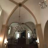L'ambiente � suddiviso in due navate sovrastate da volte a vela e Dal soffitto scendono sette lampadari in vetro